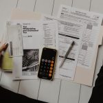 Founder reviewing financial paperwork with a pen and calculator