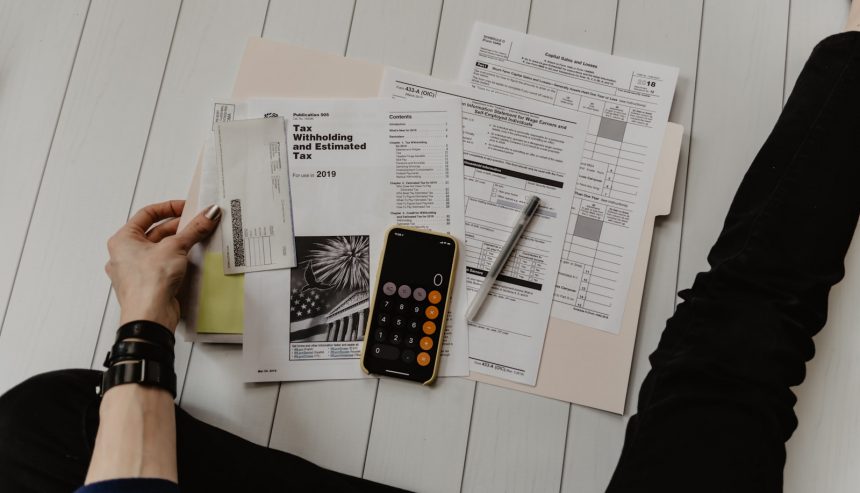 Founder reviewing financial paperwork with a pen and calculator