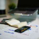 Desk with financial charts, a smartphone and notes for cash flow planning