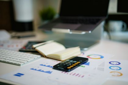 Desk with financial charts, a smartphone and notes for cash flow planning