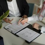 Two co-founders reviewing printed documents together at a table