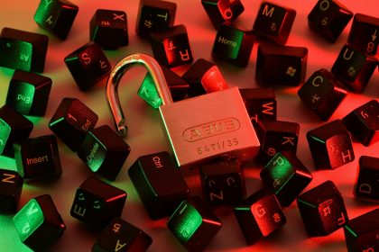 Open padlock among scattered keyboard keys under coloured light