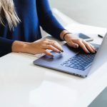 Knowledge worker reviewing output on a laptop at a bright desk