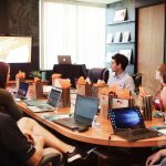 Manager presenting a budget proposal to colleagues around a meeting table