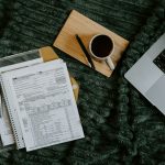 Freelancer paperwork with a laptop, calculator and coffee