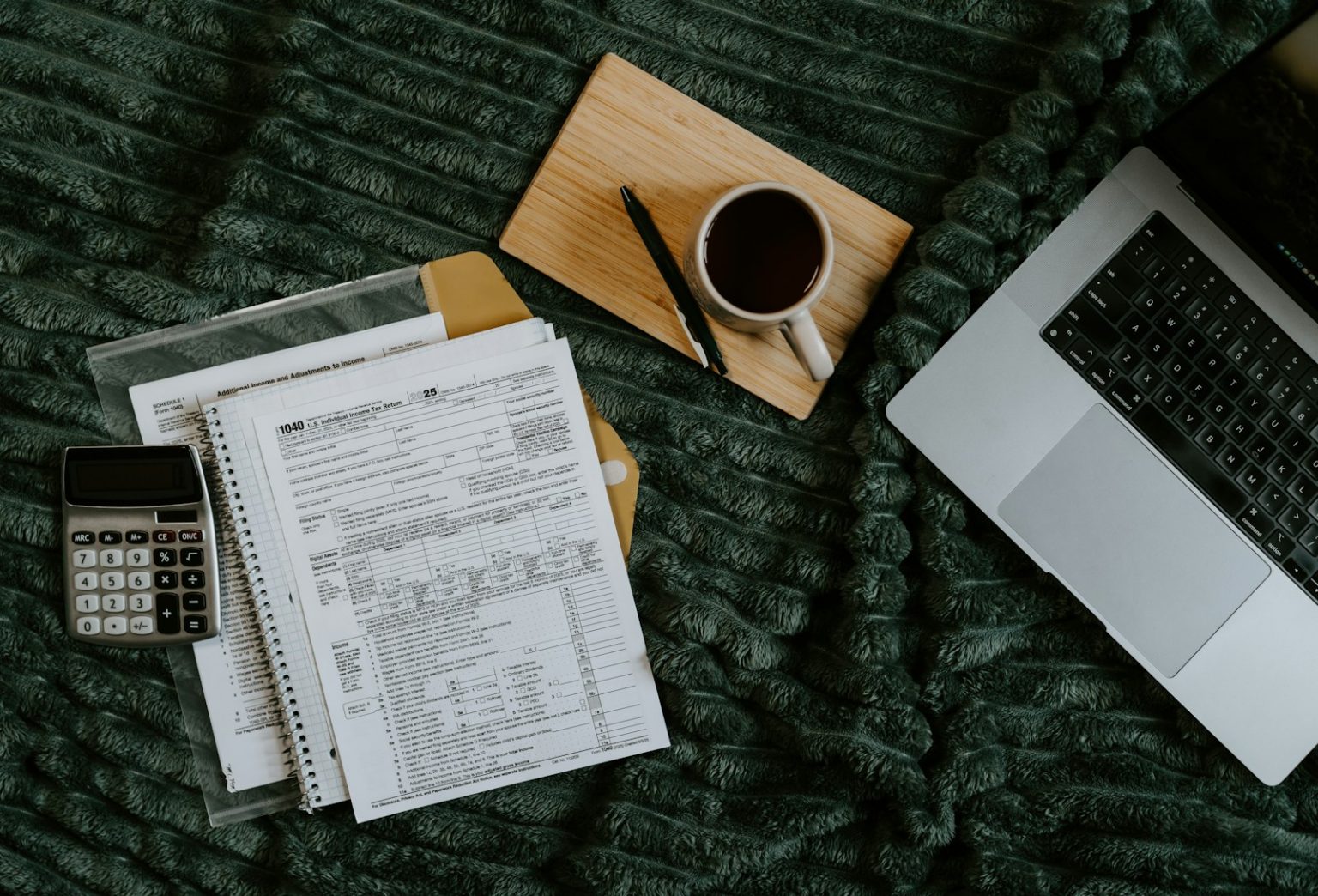 Freelancer paperwork with a laptop, calculator and coffee