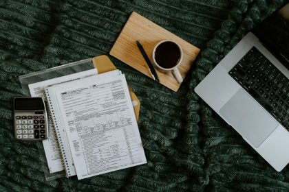 Freelancer paperwork with a laptop, calculator and coffee