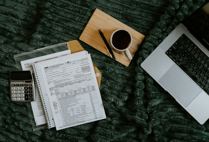 Freelancer paperwork with a laptop, calculator and coffee