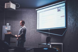 Speaker presenting from a lectern to a seated audience