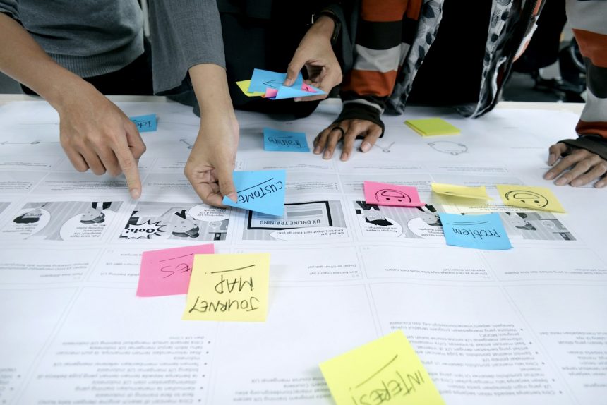 Development team mapping work with sticky notes on a wall