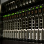 Server rack with blinking green status lights in a small equipment room