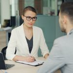 Two people conducting a job interview across an office desk