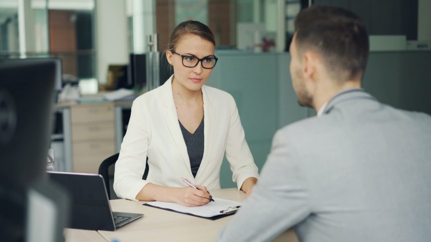 Two people conducting a job interview across an office desk