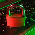 Red padlock resting on a black computer keyboard